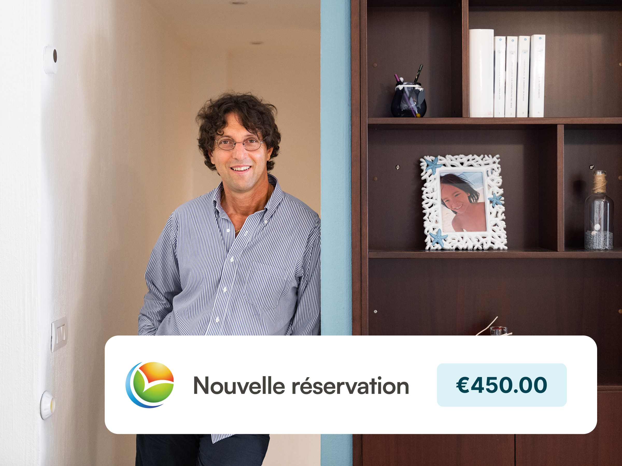 A happy host standing in his vacation rental next to a decorated shelve