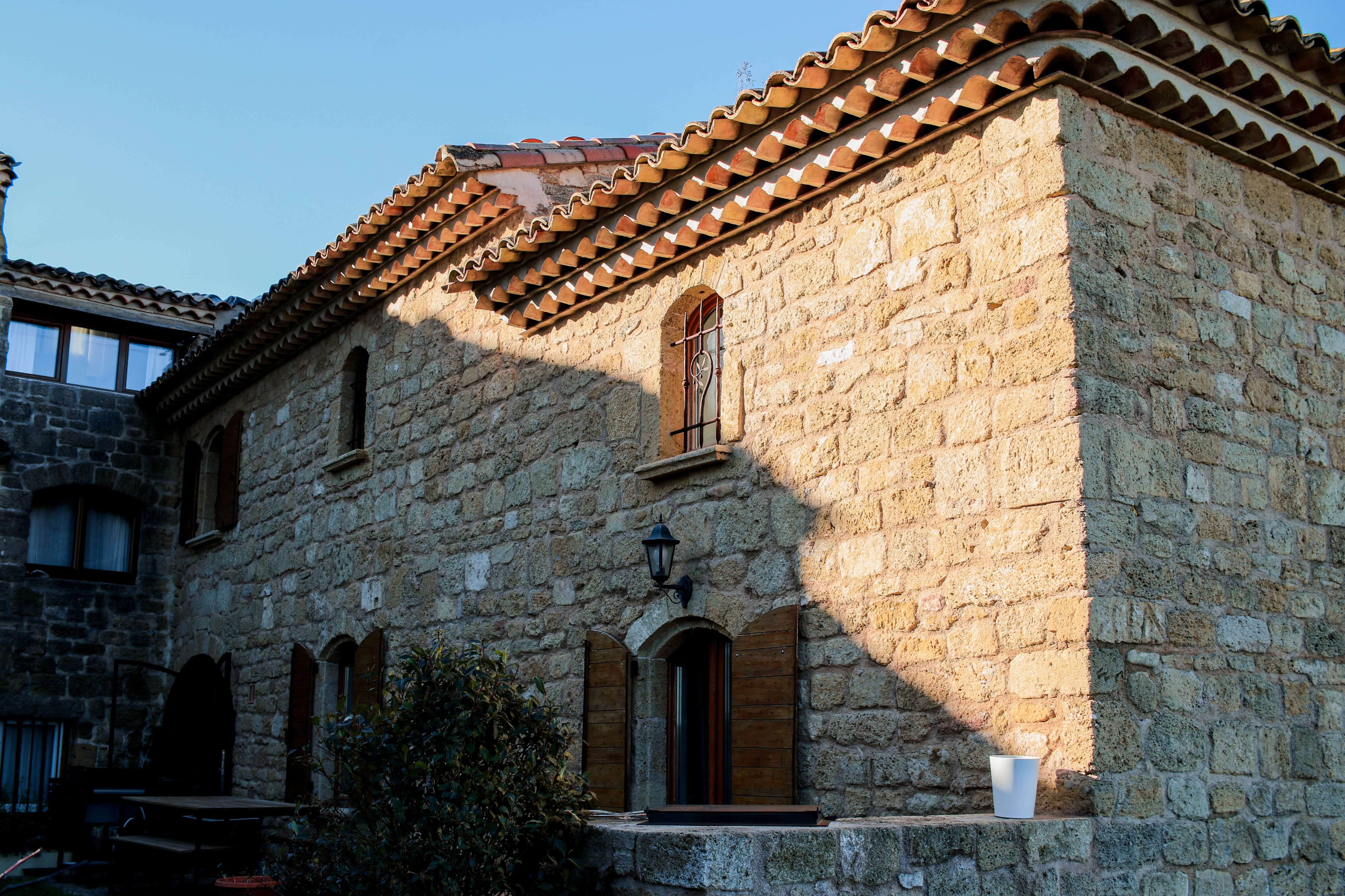 Casa rural de piedra con tejado de teja árabe a la luz del atardecer, ideal para una escapada de turismo rural en España
