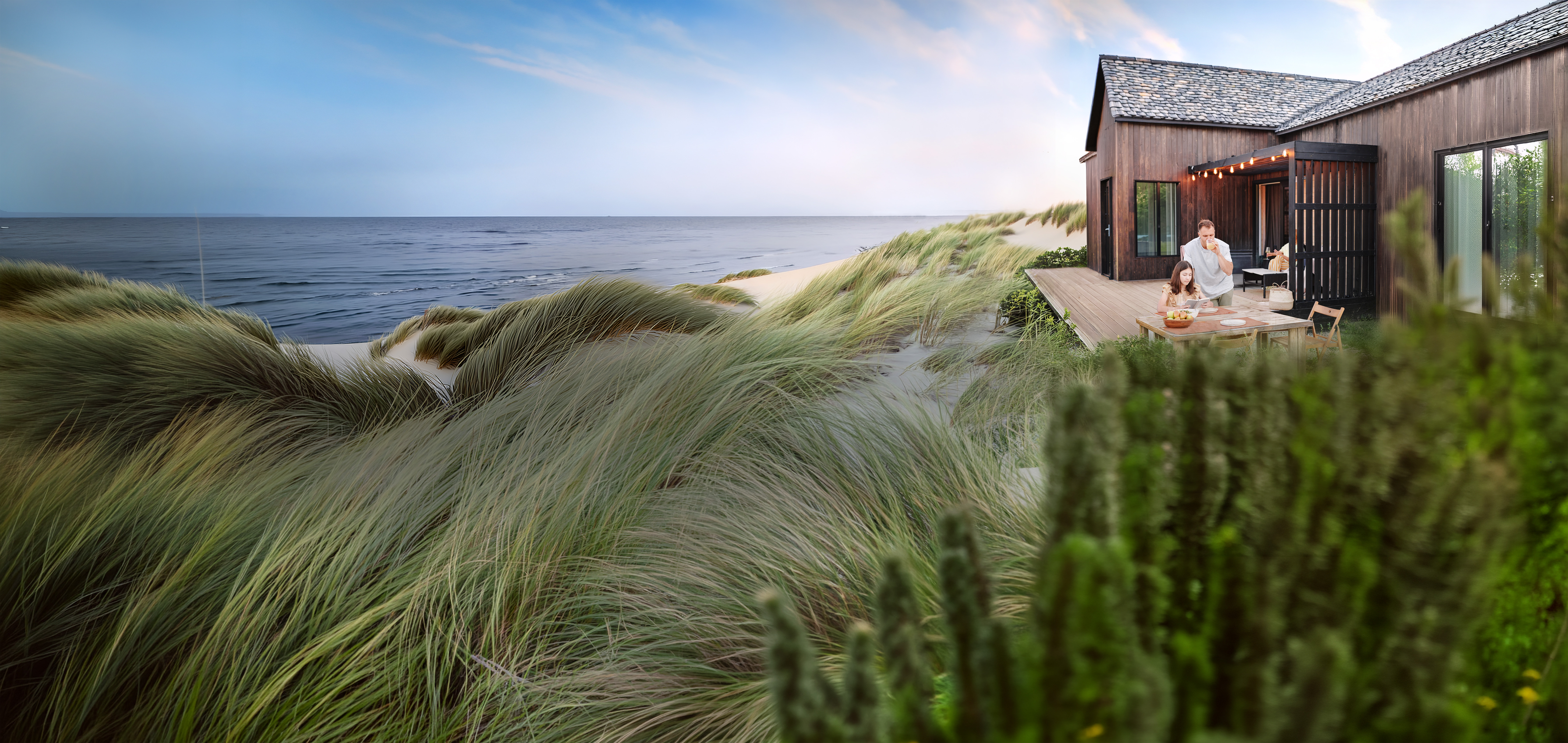 Family outside of their holiday home in the green at the baltic sea