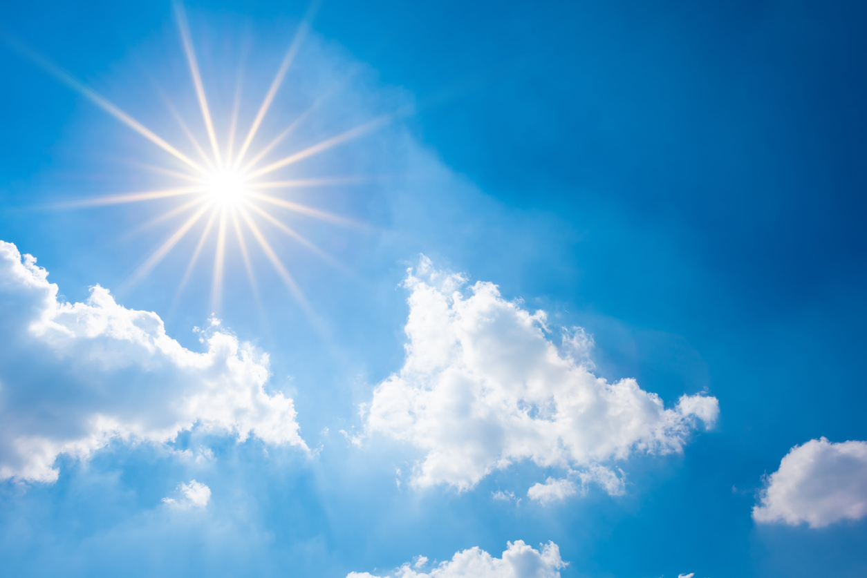 Blue sky with bright sun and clouds