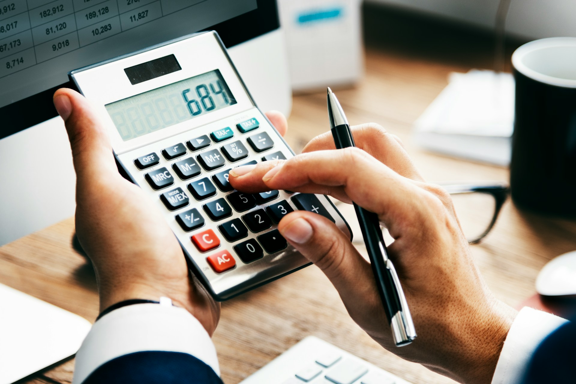 A man calculating the price of his holiday rental on a calculator