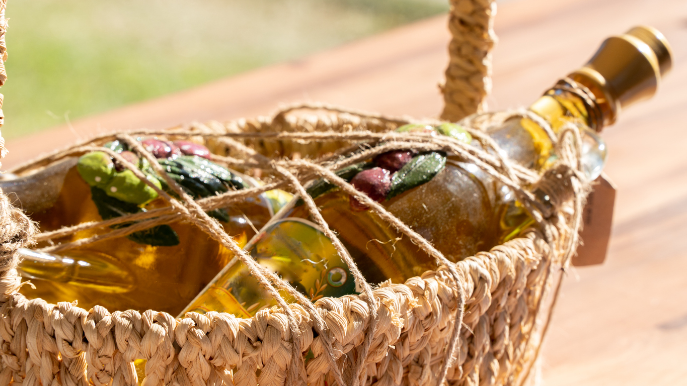 Olive oil in a glass bottle in a braided straw basket Olive oil in a glass bottle in a braided straw basket