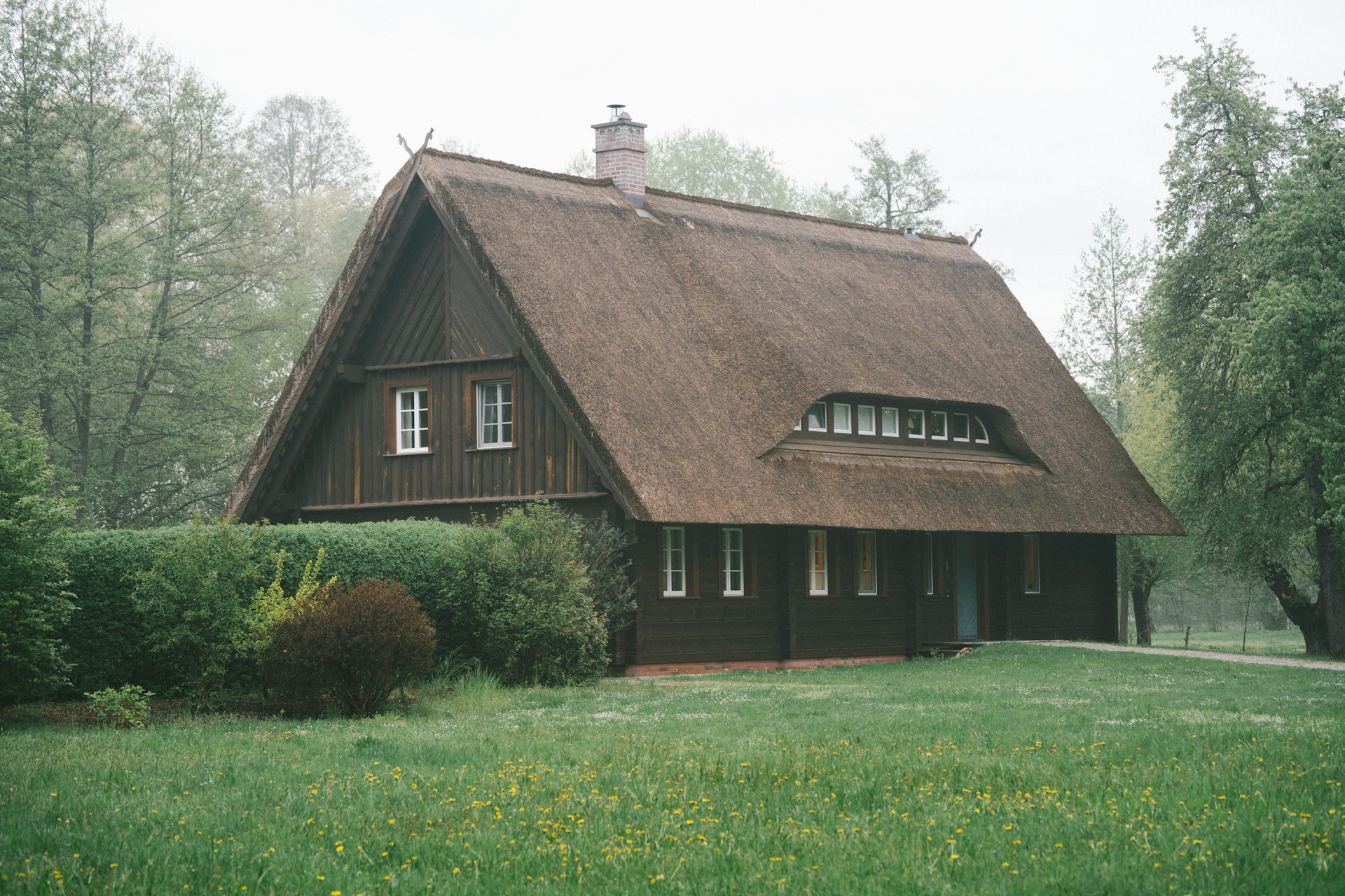 Großes Holzhaus mit grünem Garten