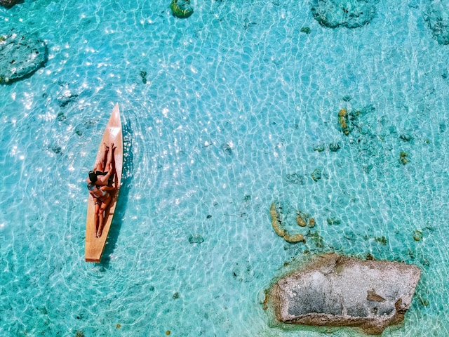 Blaues Wasser und 2 Frauen auf Surfboard