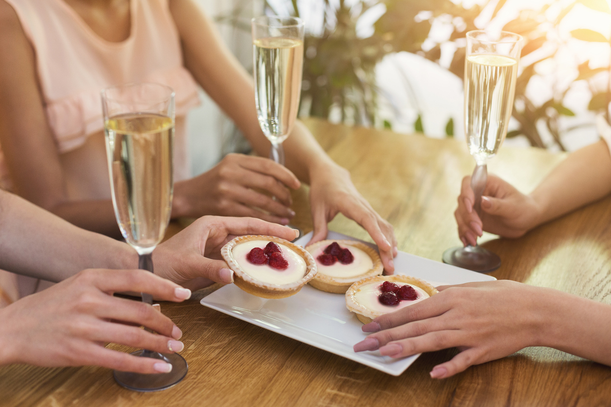 Small cake and champagne glasses in gerls hands Small cake and champagne glasses in gerls hands