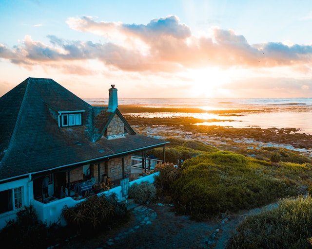 Sebastian Staines auf Unsplash Haus an der Küste über der die Sonne untergeht