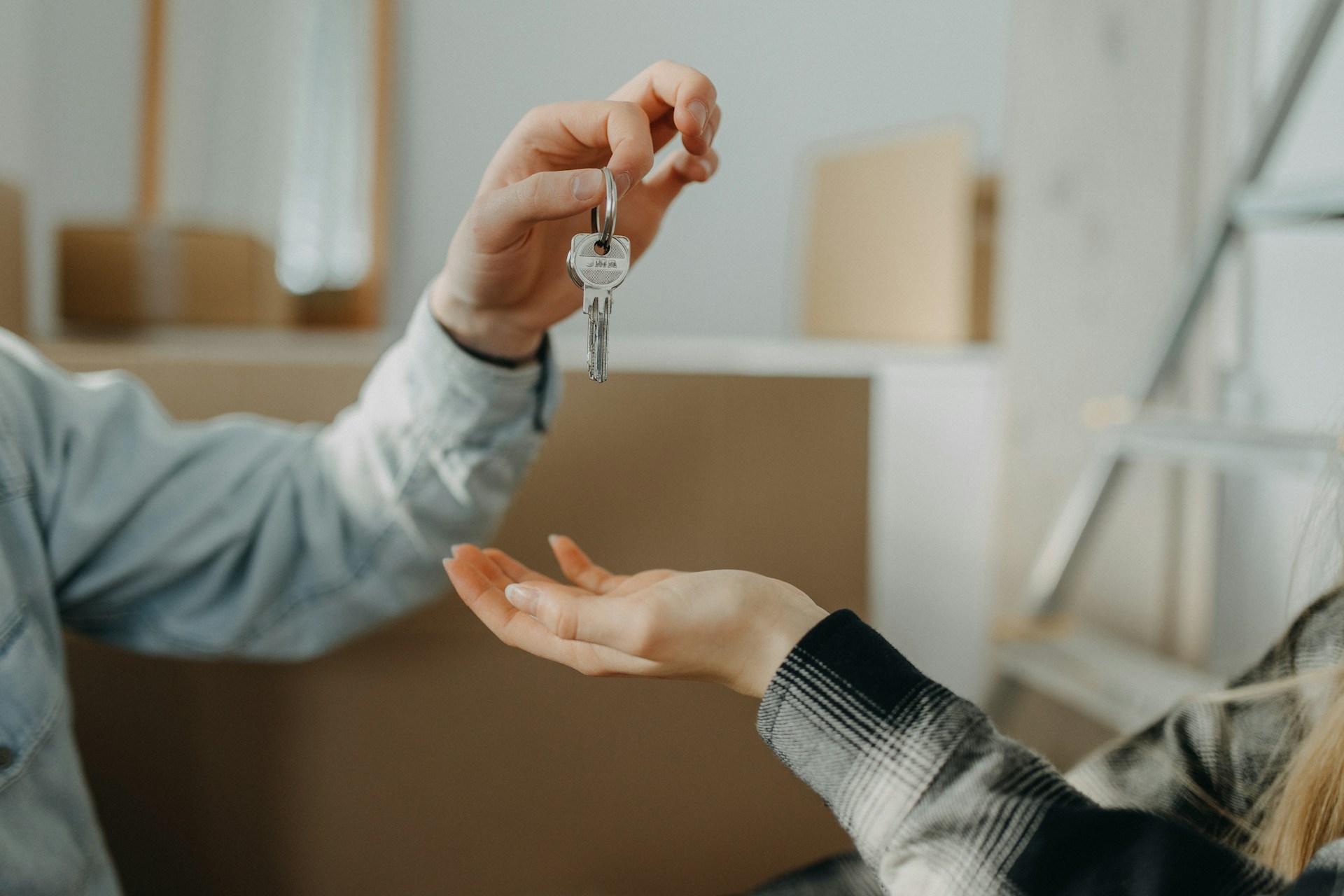 A holiday home host handing over the keys to a guest at check-in, the moment when the Inventory and Condition Report is presented and signed.