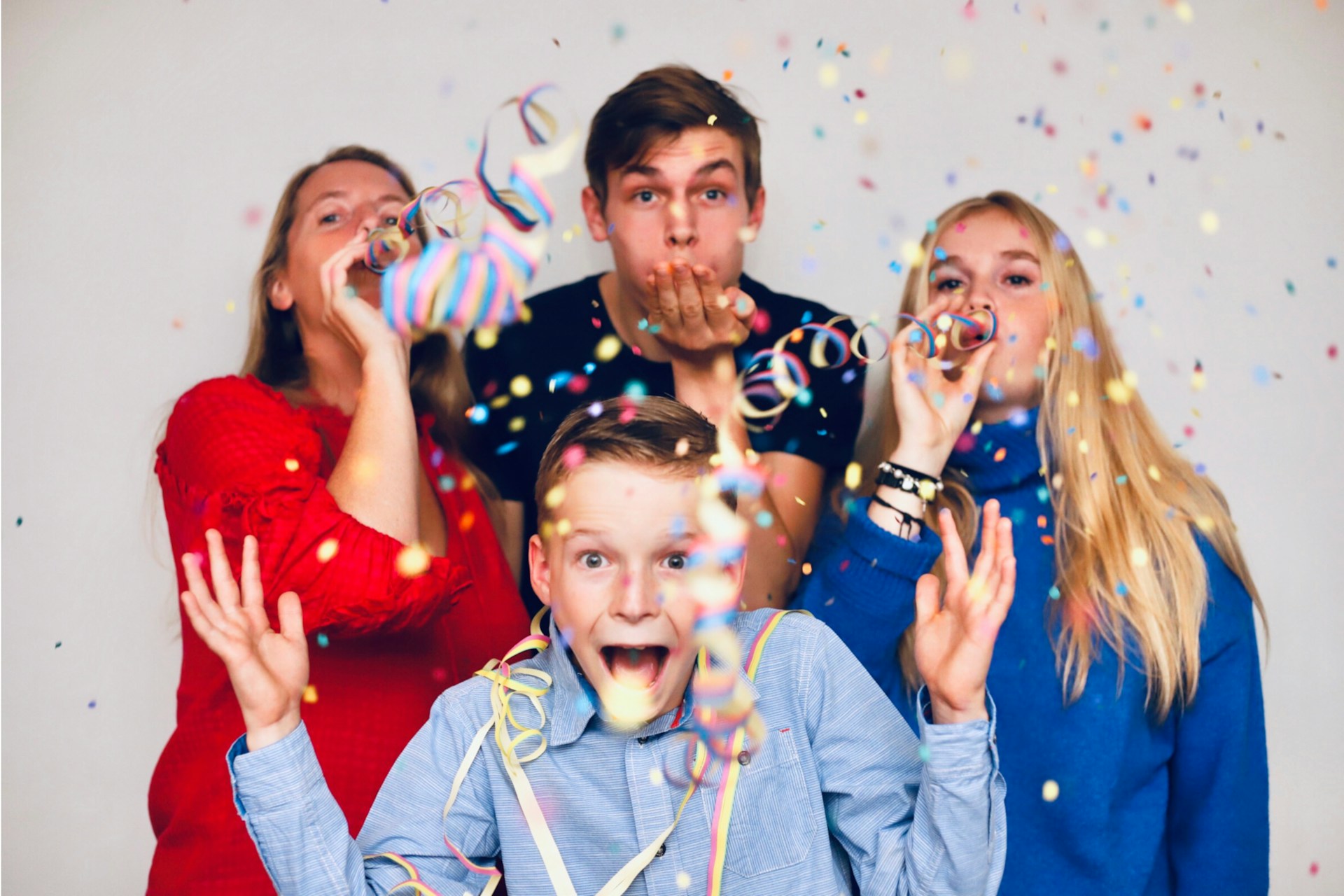 Family celebrating New Year's Eve with confetti and streamers representing holiday rental guests enjoying the festivities