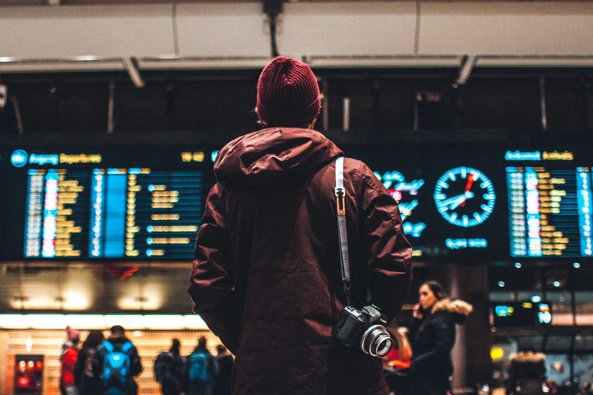 erik odiin_unsplash Person steht vor Auskunft Tafel am Flughafen
