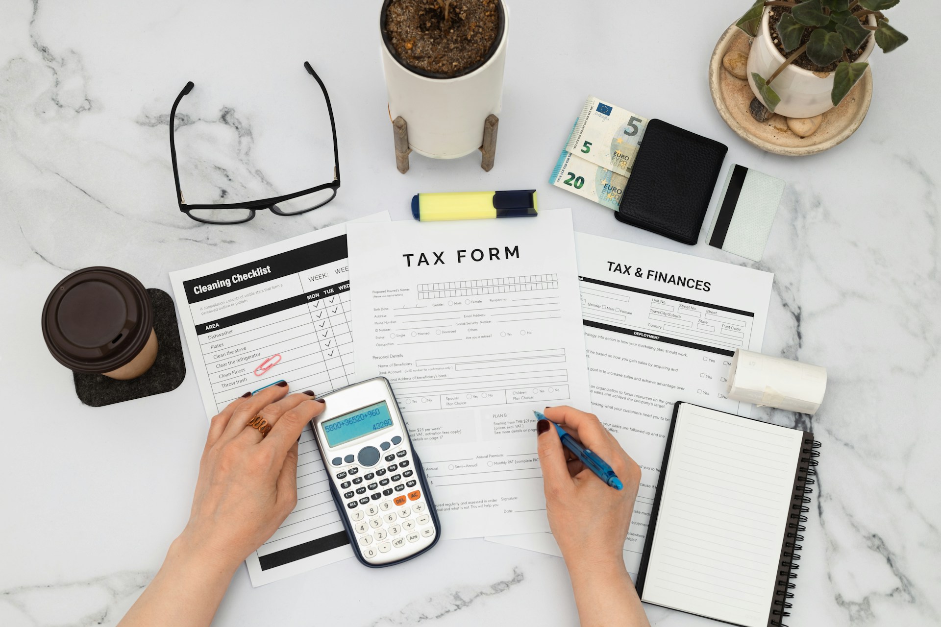behnam-norouzi-QMDt3H2DysU-unsplash Person filling out tax forms and using a calculator with Euro banknotes on a desk