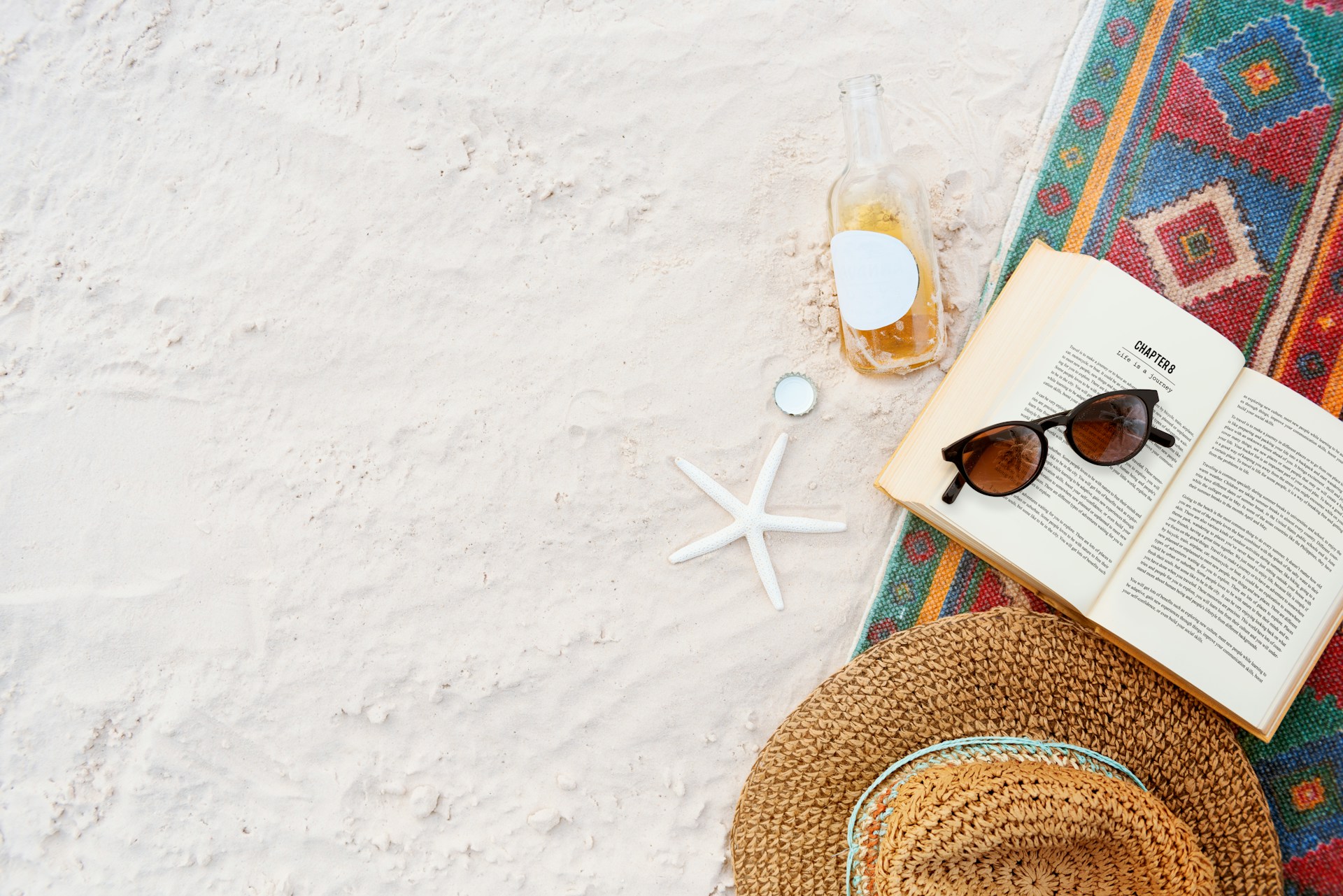 getty-images-jytGozz9FKk-unsplash Buch, Hut, Sonnenbrille un d Seestern am Strand