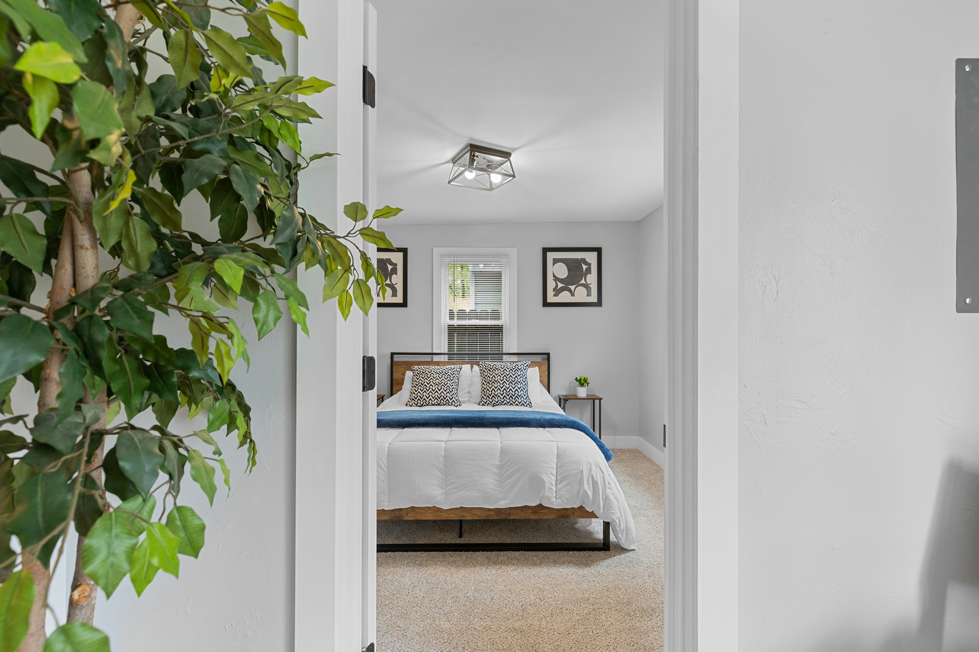 Schlafzimmer mit Bett und Pflanze vor Schlafzimmer